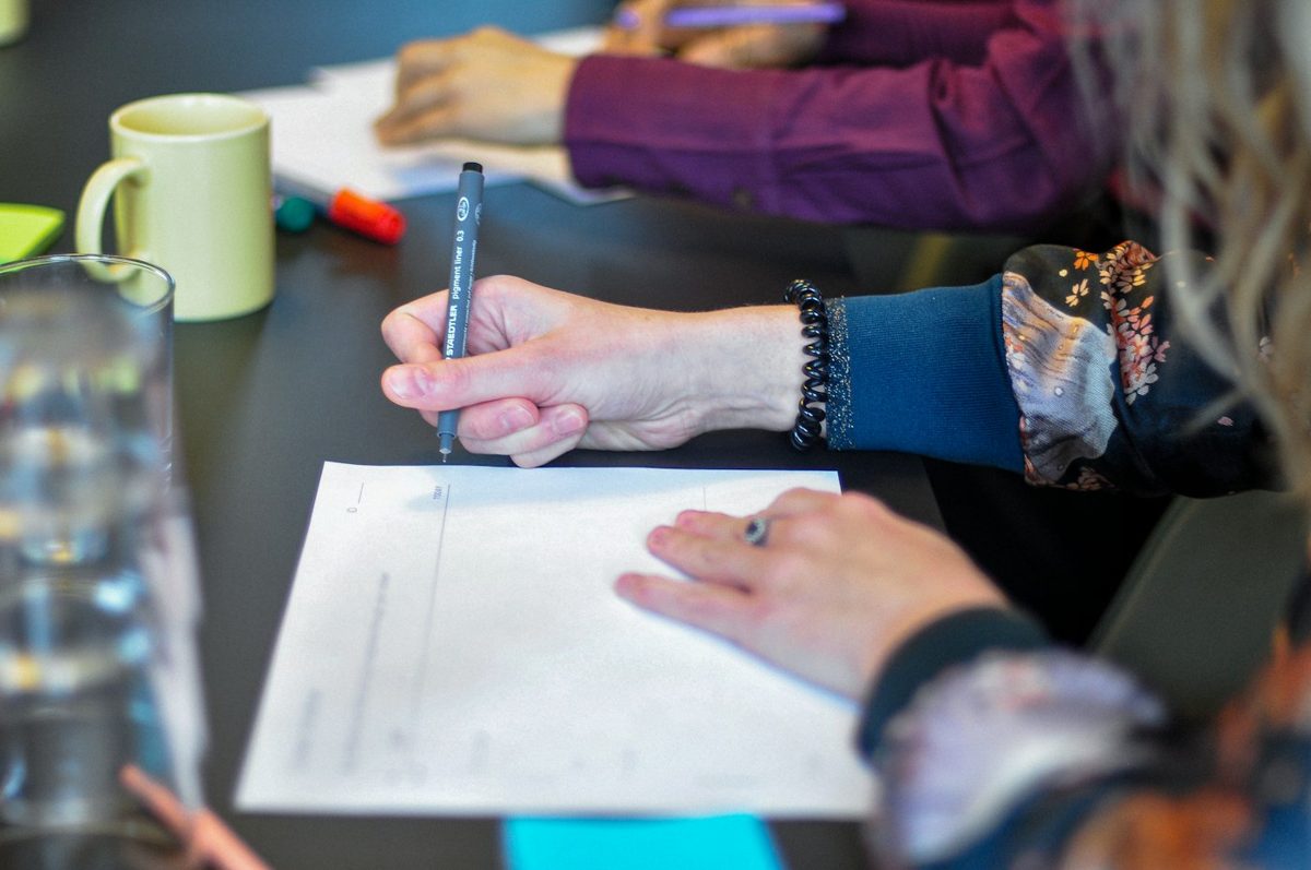 Workshop with people writing around a table